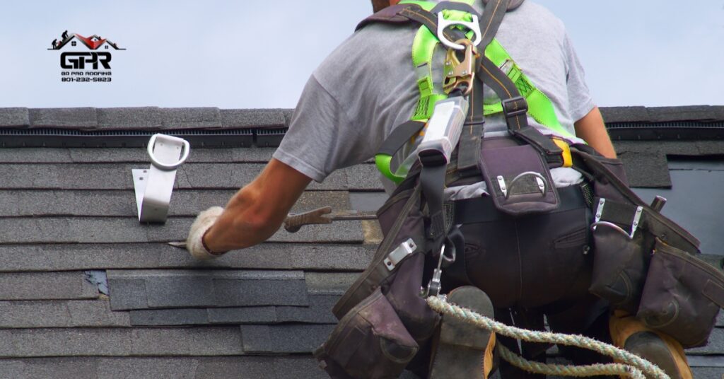 Roofer replacing shingles on a Utah home under clear sky