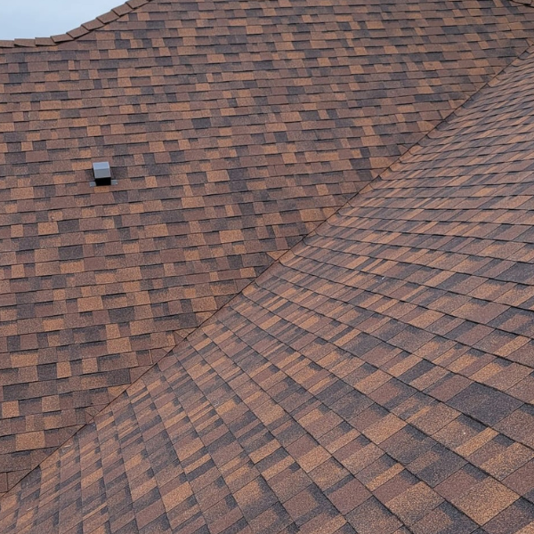 Crew installing asphalt shingles on a sloped roof