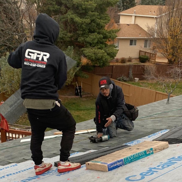Go Pro Roofing team installing shingles on a pitched roof