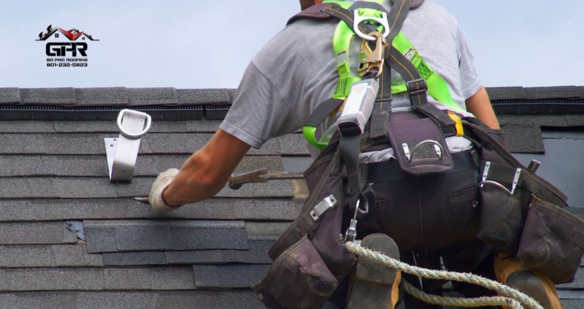 Roofer replacing shingles on a Utah home under clear sky