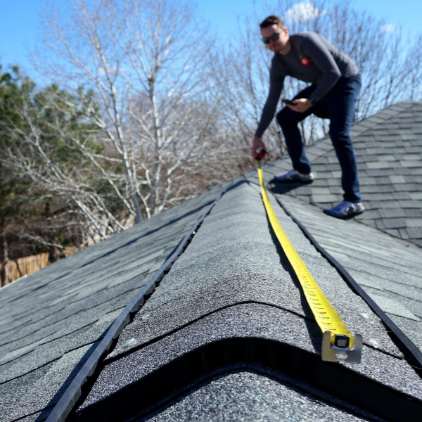 Roofing contractor inspecting shingles during an official roof inspection in Utah
